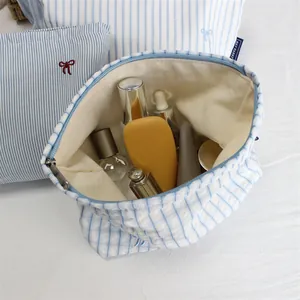 Blue striped canvas makeup bag with bow embroidery and spacious storage interior