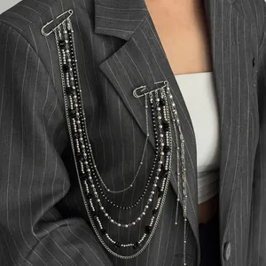 Detail of hip-hop tassel chain brooch with silver pins and black beads on suit