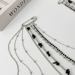 Detail of silver chain brooch with black stone beads on layered tassels for suits