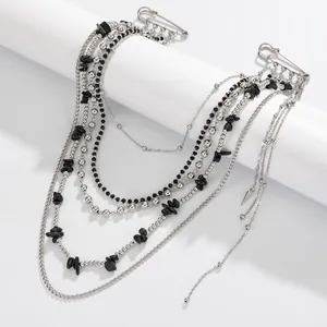 Macro detail of gothic punk chain brooch with black stone beads and silver safety pins
