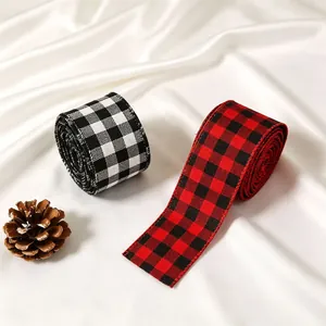 Detail of red and black buffalo plaid Christmas ribbons with wire edge on white satin