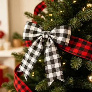 Close-up of buffalo plaid Christmas bow and ribbons on a festive pine tree with warm lights