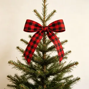 Classic red and black buffalo plaid bow ornament on a green Christmas tree top