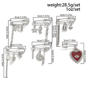 Detail of silver safety pin brooches set with heart moon pendants and metal chains