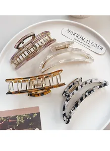 Close-up of four stylish acetate hair claws in purple and marble patterns