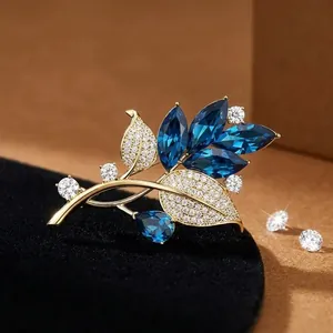Eleganter Brosche mit blauen Kristallblättern, Goldbeschichtung und weißen Zirkonia