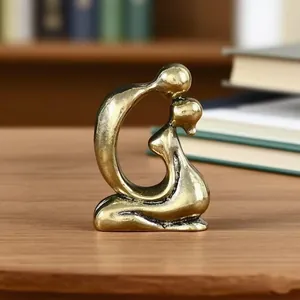 Close-up of abstract brass kissing couple statue with smooth metal texture for home decor