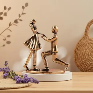 Macro detail of bronze kissing couple statue on a smooth white base for home decor