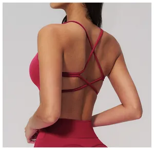 Dettaglio del reggiseno sportivo magenta con spalline incrociate e tessuto opaco elastico