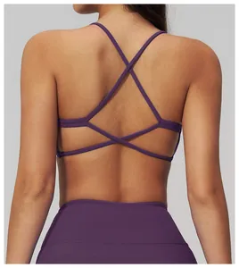 Dettaglio del reggiseno yoga viola con spalline incrociate e leggings fitness a vita alta