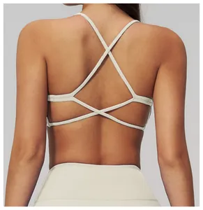 Dettaglio delle spalline incrociate sul reggiseno sportivo beige per yoga e corsa
