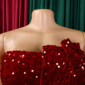 Detail of red sequined velvet off-shoulder dress featuring delicate ruffled neckline textures