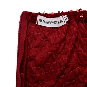 Close-up of wine red sequin dress waist showing invisible zipper and size M label