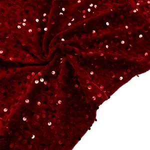 Detail shot of the deep red sequined velvet fabric with elegant metallic reflections
