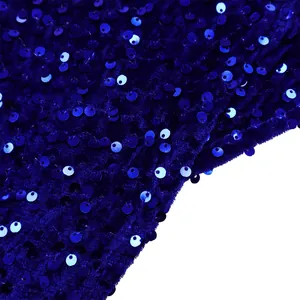 Macro detail of royal blue sequin fabric with dense metallic shimmer on velvet base