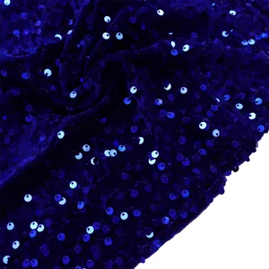 Close-up of deep blue sequins on soft velvet fabric for elegant evening gowns