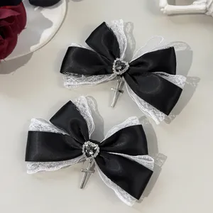 Detalle de lazos góticos de encaje con gemas de corazón y cruces plateadas
