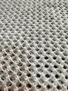 Close-up of white crochet beach dress showing hollow diamond knit texture and detail