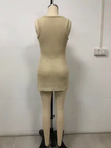 Detail of beige crochet knit beach dress showing openwork texture and back silhouette