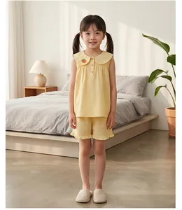 Détail du pyjama enfant à carreaux jaunes avec broderie orange et ourlet volanté