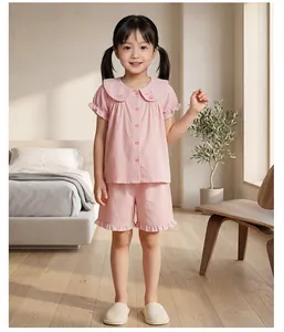 Détail d'un pyjama en coton à carreaux roses pour filles avec broderie lapin et volants