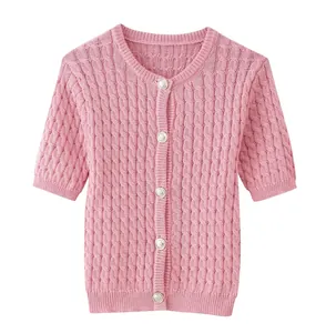 Close-up of pink knit cardigan featuring cable-knit texture and silver embossed buttons