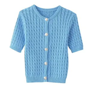 Detail of cable knit pattern and silver embossed buttons on sky blue short cardigan