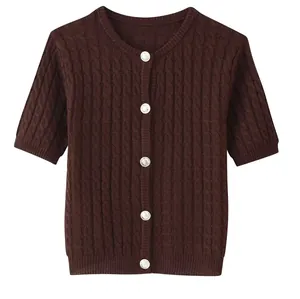 Detail of dark brown cable-knit cardigan with round neck and textured silver buttons