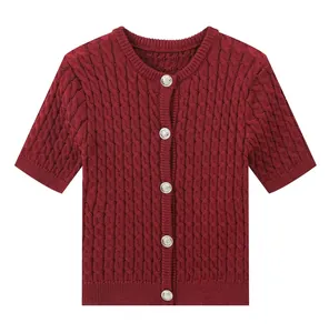 Detail of burgundy cable-knit short sleeve cardigan featuring silver embossed buttons