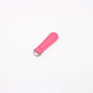Macro detail of magenta PU leather zipper pull with silver D-ring and neat stitching
