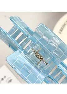 Detail of light blue hair claw clip with white grid pattern and translucent finish