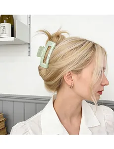 Close-up of a light green checkered rectangular hair claw clip worn on a messy bun