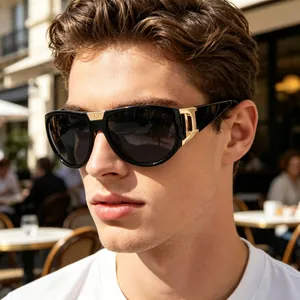 Close-up of luxury black oversized sunglasses with gold metal decorative temple detail