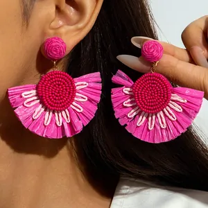 Handmade fan-shaped raffia earrings in bright fuchsia pink with bohemian beaded texture