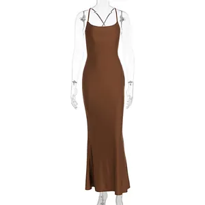 Detail of dark brown satin dress featuring cross back straps and silky texture