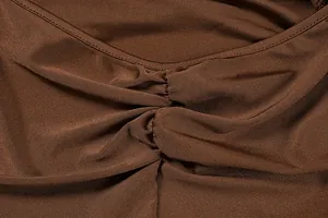 Detail view of the twist knot neckline on this dark brown satin knit sexy dress