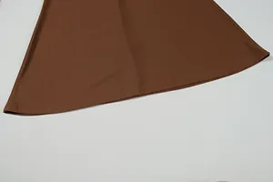 Detail of deep brown satin dress hem showing neat stitching and draped fabric texture