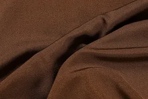 Macro shot of dark brown satin knit fabric showing soft texture and glossy draped folds