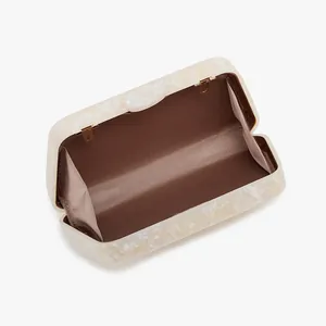 Macro view of marble acrylic evening bag with brown fabric lining and gold hinge