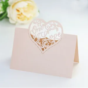 Macro detail of laser-cut One Love heart table card with peach pearlescent texture