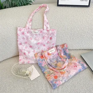 Close-up of lace floral tote bags showing textured floral patterns on a cozy sofa