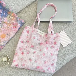 Detailed embroidery on a soft pink floral lace tote bag featuring 3D rose patterns