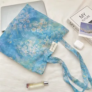 Detail of light blue floral lace tote bag with white woven label on cotton fabric