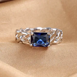 Close-up of Cuban link ring with a large rectangular blue zircon and silver finish