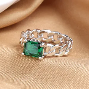 Vintage silver chain ring featuring a large emerald-cut green zircon on silk fabric