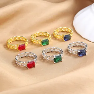 Luxury Cuban chain rings set with colorful emerald-cut zircons on elegant satin fabric