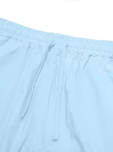 Dettaglio pantaloni in lino azzurro con vita elastica e coulisse piatta in tinta