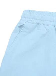Dettaglio dei pantaloni in cotone e lino azzurro con elastico in vita e tasche laterali
