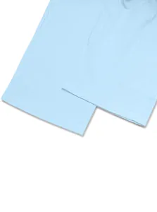 Dettaglio dei pantaloni in lino azzurro che mostra l'orlo a doppia cucitura e la trama