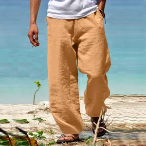 Close-up of linen blend wide-leg trousers featuring woven drawstring on beach backdrop